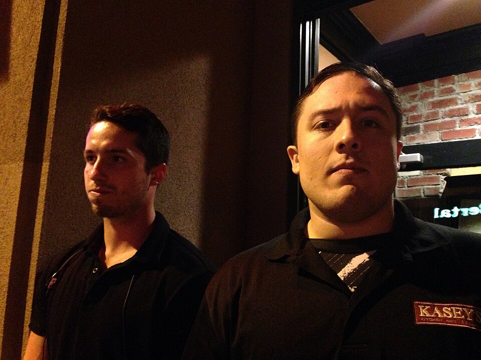 Two bouncers standing at a venue entrance