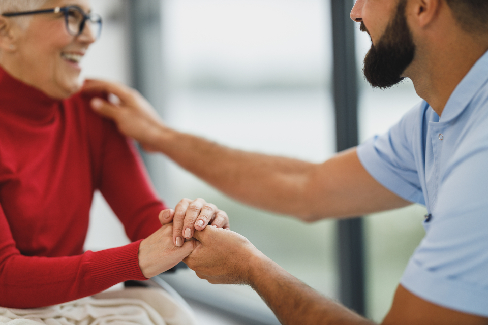 Caregiver gently assisting an elderly person at home